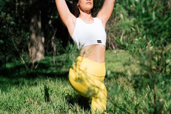 Woman in a balanced yoga pose in a tranquil garden.